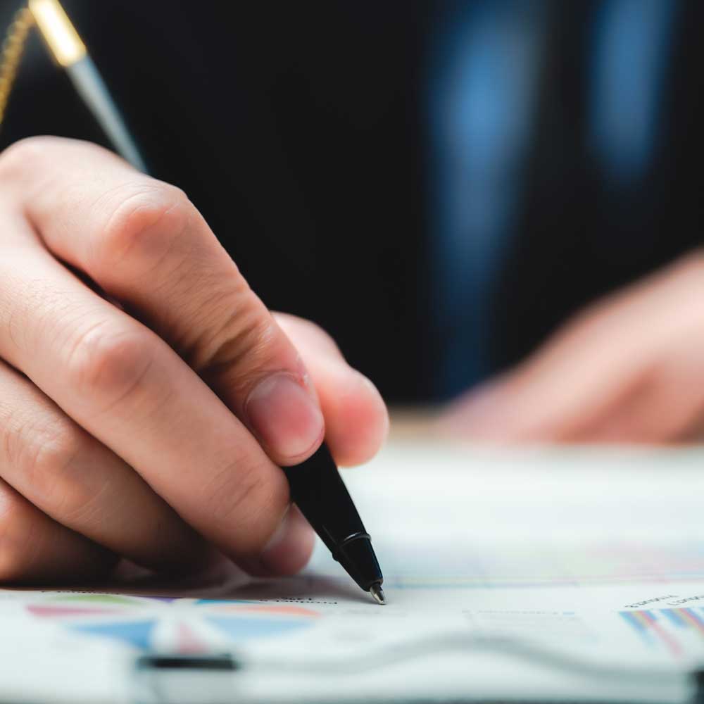 Man writing on paper with pen